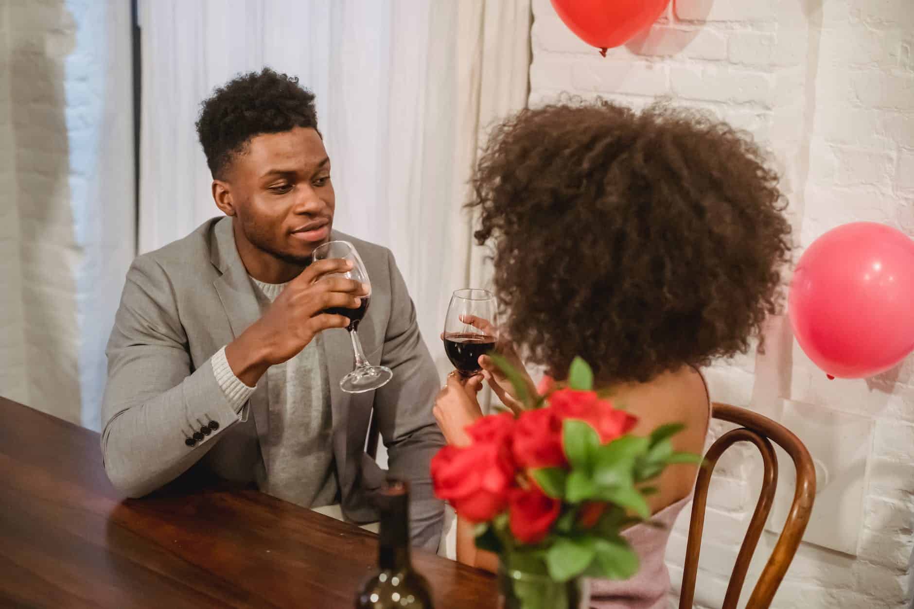 african american couple having date while drinking wine at table
